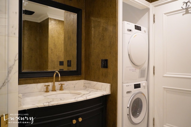 502 Park Ave Unit 12J, New York City, NY 10022 - bathroom featuring stacked washer and clothes dryer, vanity, and crown molding