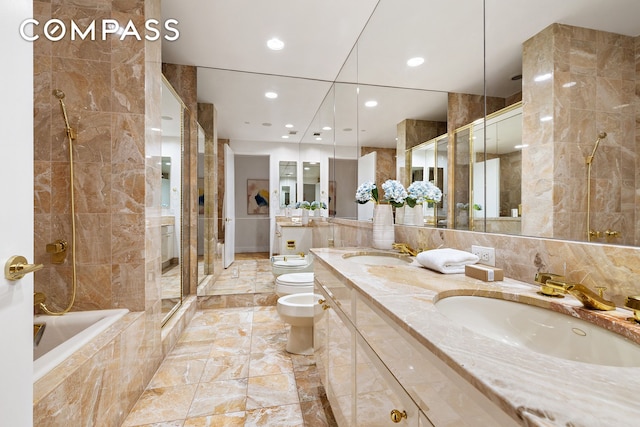 bathroom with a bidet, toilet, a stall shower, recessed lighting, and double vanity