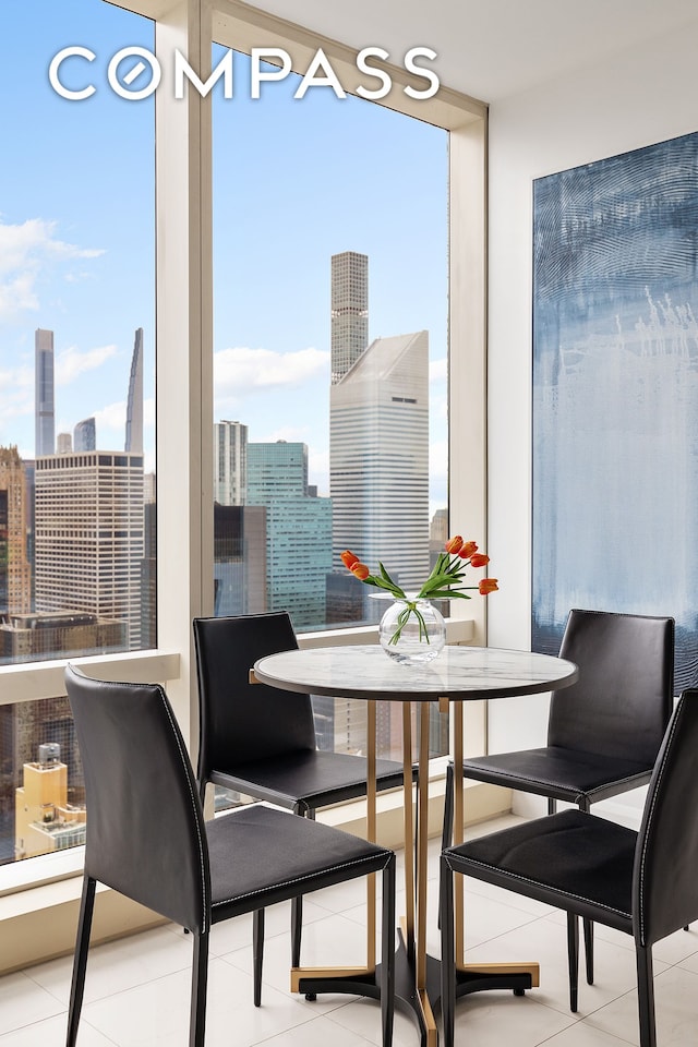 dining area featuring healthy amount of natural light, a skyline view, floor to ceiling windows, and tile patterned flooring