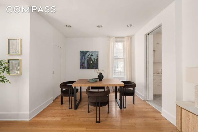 dining room featuring baseboards and light wood finished floors