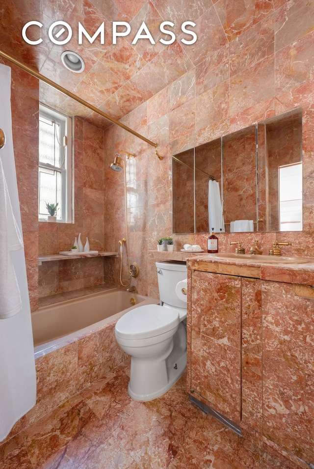 bathroom with tiled shower / bath combo, tile walls, toilet, and vanity