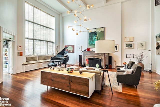 257 W 86th St Unit 13A/14A, New York City, NY 10024 - living room with a chandelier, dark wood-type flooring, a towering ceiling, a fireplace, and baseboards