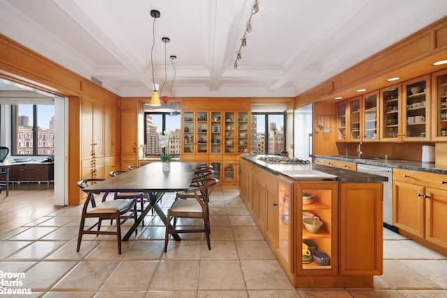 kitchen featuring a sink, beamed ceiling, glass insert cabinets, a kitchen island, and appliances with stainless steel finishes