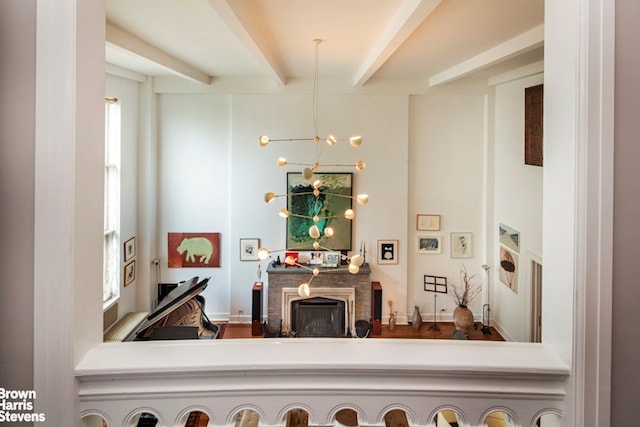 living area with a fireplace, beam ceiling, and an inviting chandelier