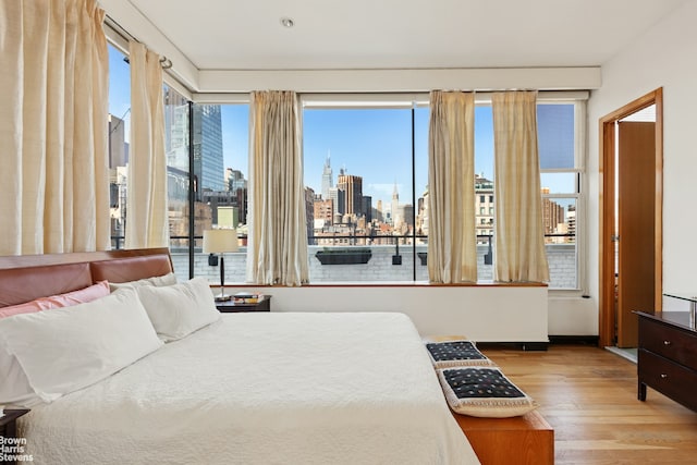118 E 25th St Unit Ph12Thfl, New York City, NY 10010 - bedroom featuring wood-type flooring, a view of skyline, and access to outside