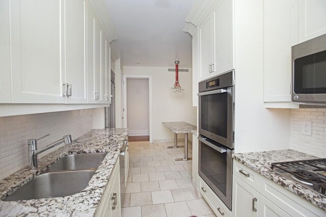 905 W End Ave Unit 142, New York City, NY 10025 - kitchen featuring a sink, visible vents, white cabinetry, decorative backsplash, and appliances with stainless steel finishes