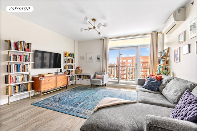 living room with a wall mounted air conditioner, wood finished floors, and a chandelier