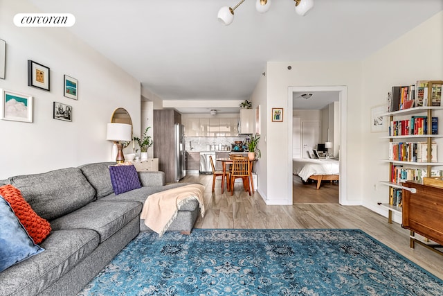 living area featuring light wood-style flooring and baseboards