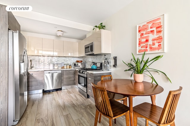 kitchen featuring stainless steel appliances, light countertops, and modern cabinets