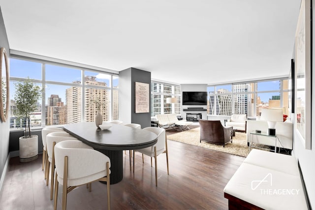 160 W 66th St Unit 17B, New York City, NY 10023 - dining space featuring plenty of natural light, wood finished floors, and a glass covered fireplace