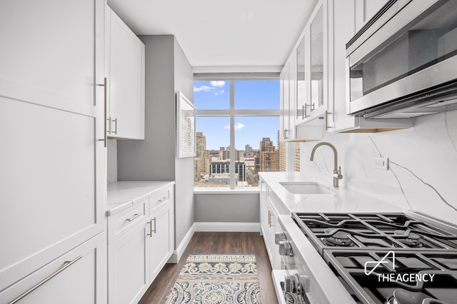 160 W 66th St Unit 17B, New York City, NY 10023 - kitchen with appliances with stainless steel finishes, white cabinetry, and light stone countertops