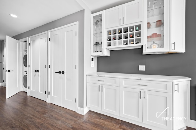 160 W 66th St Unit 17B, New York City, NY 10023 - laundry area featuring stacked washing machine and dryer, dark wood finished floors, and recessed lighting