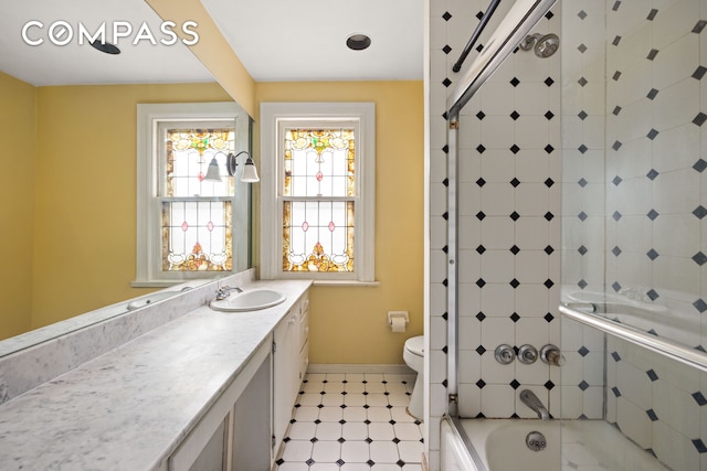 bathroom with tiled shower / bath combo, baseboards, toilet, and vanity
