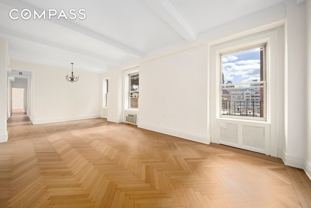 156 E 79th St Unit 9C, New York City, NY 10075 - empty room featuring a chandelier, beam ceiling, baseboards, and a wall mounted air conditioner