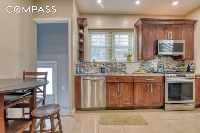 232 Maple St, New York City, NY 11225 - kitchen featuring appliances with stainless steel finishes, a sink, decorative backsplash, light stone countertops, and recessed lighting