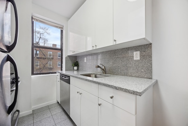 kitchen with a sink, stainless steel dishwasher, baseboards, decorative backsplash, and white cabinetry