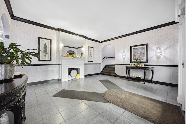 lobby with crown molding, wallpapered walls, and stairs