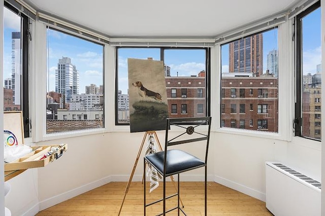 137 E 36th St Unit 11-B, New York City, NY 10016 - sunroom / solarium featuring a skyline view, radiator heating unit, and plenty of natural light