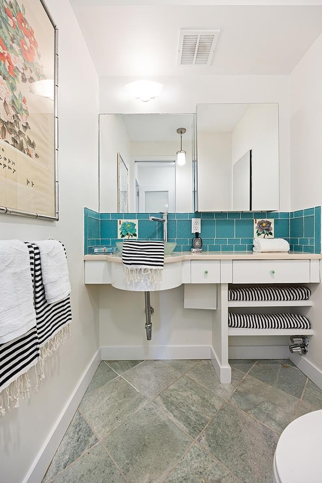 137 E 36th St Unit 11-B, New York City, NY 10016 - bathroom with baseboards, toilet, and stone tile flooring