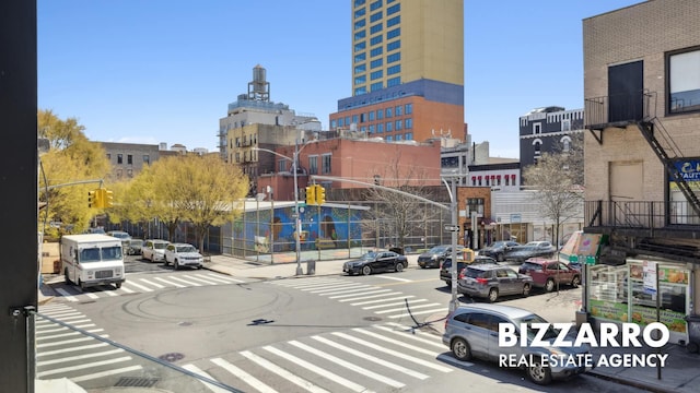 553 W 182nd St Unit 2R, New York City, NY 10033 - view of asphalt street featuring street lights, sidewalks, curbs, a view of city, and traffic signs