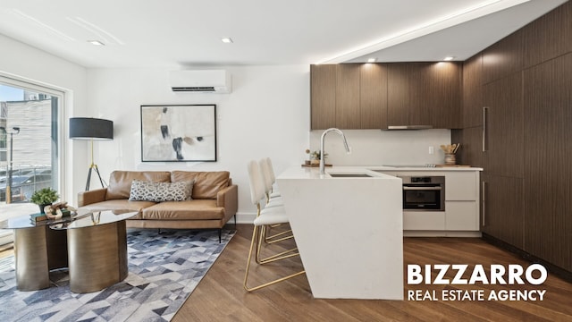553 W 182nd St Unit 2R, New York City, NY 10033 - kitchen with a wall mounted AC, oven, a sink, light countertops, and dark wood-style floors