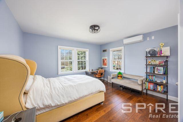 72-03 Ingram St Unit H0Use, New York City, NY 11375 - bedroom featuring a wall mounted air conditioner, wood finished floors, and baseboards