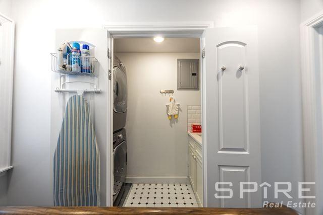 72-03 Ingram St Unit H0Use, New York City, NY 11375 - washroom featuring stacked washer and clothes dryer, electric panel, and baseboards