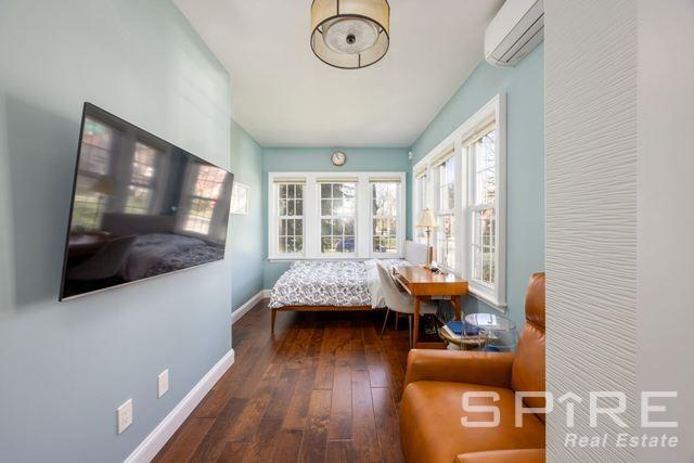 72-03 Ingram St Unit H0Use, New York City, NY 11375 - bedroom featuring a wall unit AC, baseboards, and wood-type flooring