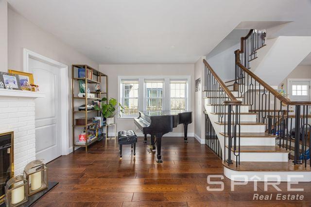 72-03 Ingram St Unit H0Use, New York City, NY 11375 - foyer entrance featuring a brick fireplace, stairs, and hardwood / wood-style flooring