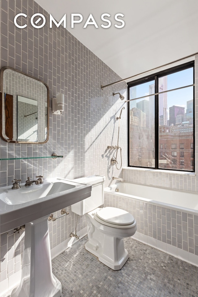 380 Rector Pl Unit 7Lmn, New York City, NY 10280 - bathroom featuring tiled shower / bath, tile walls, a city view, and tile patterned floors
