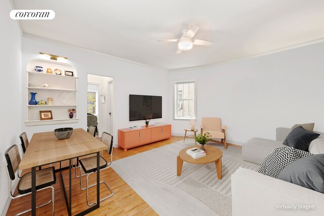living room with crown molding, plenty of natural light, ceiling fan, and wood finished floors