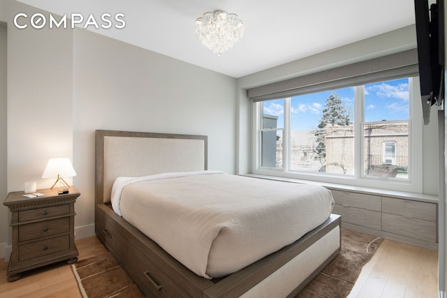 bedroom with an inviting chandelier and light wood finished floors