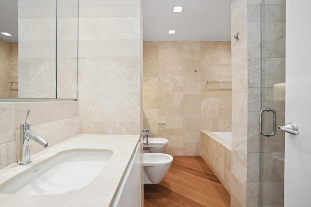 146 W 57th St Unit 53A, New York City, NY 10019 - bathroom with tile walls, a bidet, toilet, a stall shower, and vanity