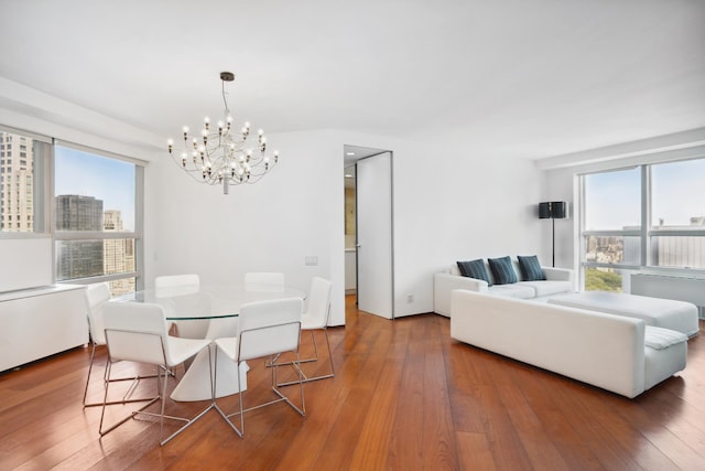 146 W 57th St Unit 53A, New York City, NY 10019 - dining room featuring a chandelier, healthy amount of natural light, and hardwood / wood-style flooring