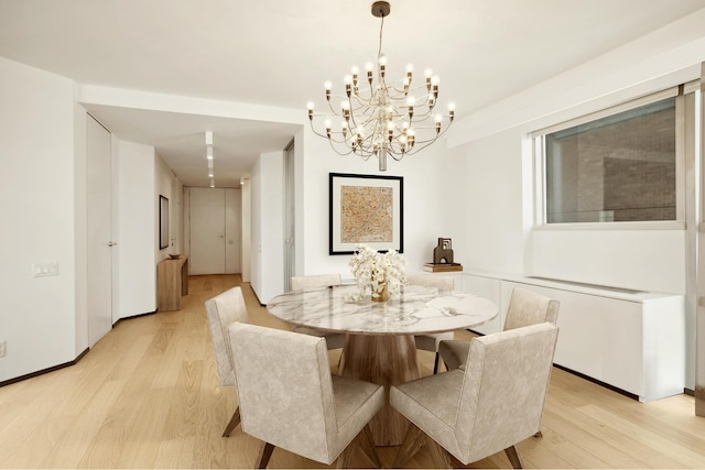 146 W 57th St Unit 53A, New York City, NY 10019 - dining room featuring light wood-type flooring and a chandelier