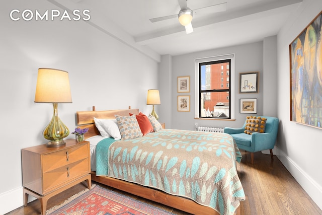 bedroom with wood finished floors, baseboards, radiator heating unit, ceiling fan, and beamed ceiling