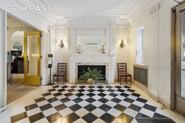 sitting room with crown molding and a high end fireplace