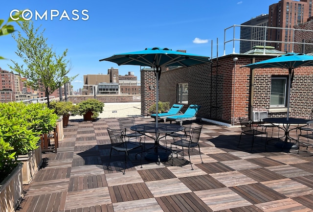 view of patio with outdoor dining area and a city view