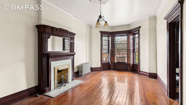 256 Decatur St, New York City, NY 11233 - unfurnished living room featuring radiator heating unit, hardwood / wood-style floors, crown molding, cooling unit, and a premium fireplace