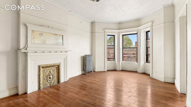 256 Decatur St, New York City, NY 11233 - unfurnished living room featuring radiator, crown molding, wood finished floors, and a textured ceiling