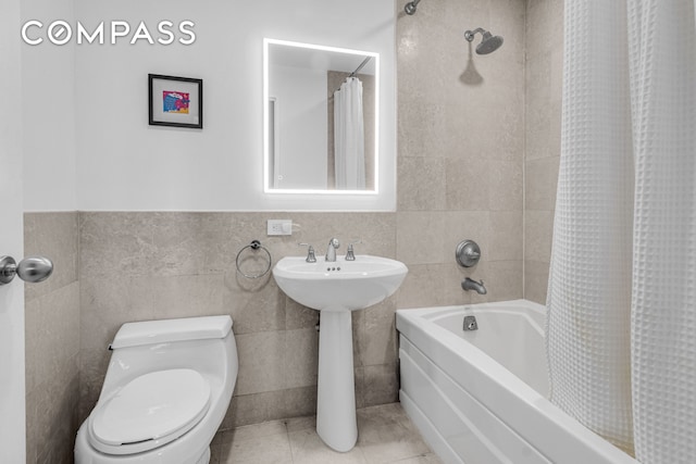 1485 5th Ave Unit 13D, New York City, NY 10035 - bathroom featuring shower / bath combo with shower curtain, tile walls, and tile patterned flooring