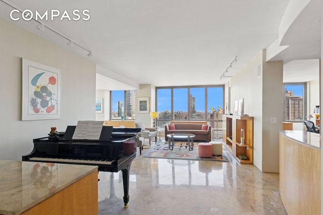 living room with rail lighting, expansive windows, and a view of city