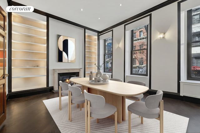 132 E 62nd St, New York City, NY 10065 - dining space with built in features, recessed lighting, wood finished floors, crown molding, and a fireplace