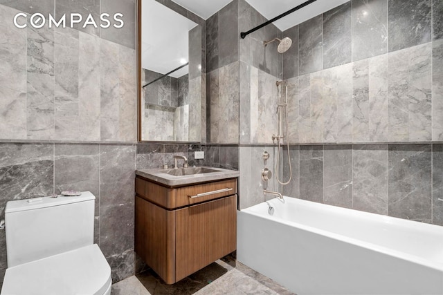 bathroom featuring tile walls, shower / washtub combination, vanity, toilet, and marble finish floor