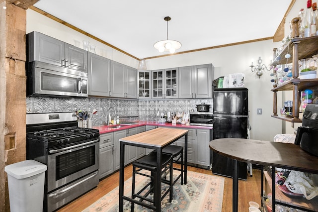 kitchen featuring gray cabinets, ornamental molding, and appliances with stainless steel finishes