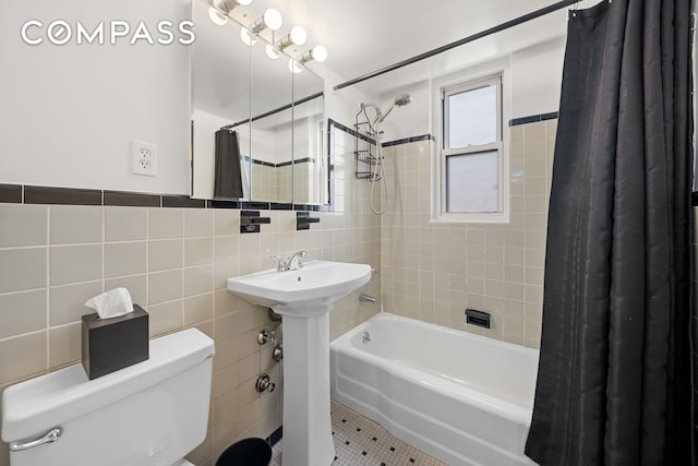 139 E 33rd St Unit 11L, New York City, NY 10016 - full bathroom featuring tile walls, toilet, shower / bathtub combination with curtain, tile patterned flooring, and a sink