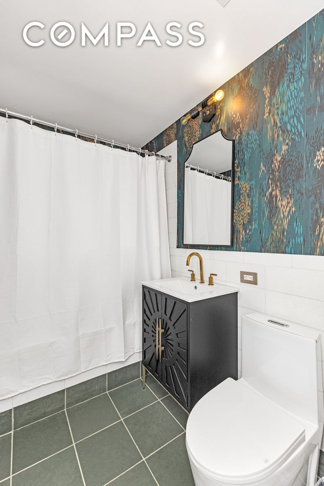 full bath featuring tile patterned floors, toilet, vanity, wallpapered walls, and tile walls