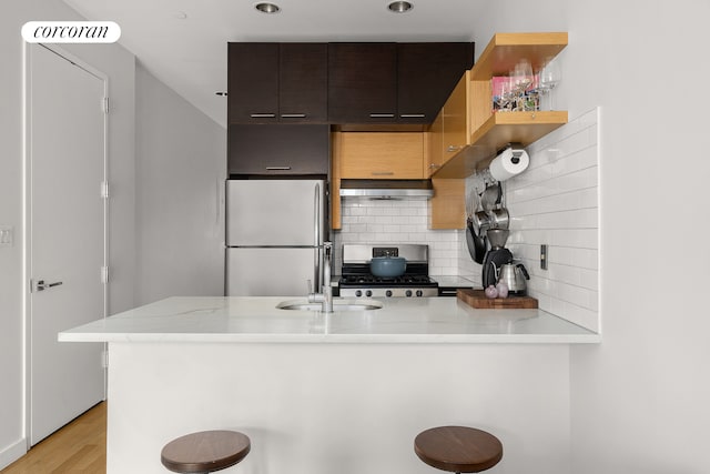 146 Clifton Pl Unit 2A, New York City, NY 11238 - kitchen featuring appliances with stainless steel finishes, a peninsula, ventilation hood, decorative backsplash, and a sink