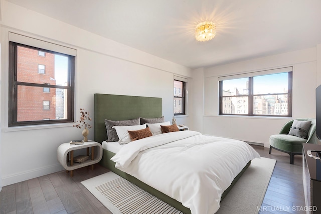 bedroom featuring baseboards, multiple windows, and wood finished floors