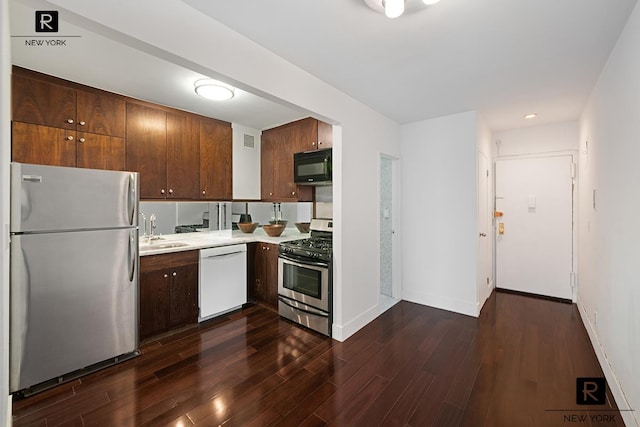 315 7th Ave Unit 16-D, New York City, NY 10001 - kitchen featuring stainless steel appliances, light countertops, a sink, dark wood-style flooring, and baseboards